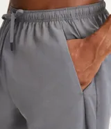 Bermuda deportiva masculina de tejido plano, con cintura elástica y cordón de ajuste. Presenta bolsillos laterales, recortes laterales texturizados, aberturas en el ruedo y un bolsillo con cierre en la parte trasera.