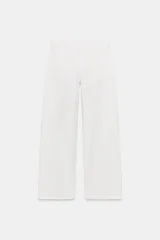 Jeans de tiro medio con diseño de cinco bolsillos y pierna ancha. Presenta un corte recto y holgado con bajo acabado sin costuras y cierre frontal con cremallera y botón metálico.