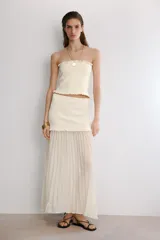 Falda midi color crema con cintura elástica y tejido plisado.