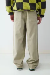 Pantalón de corte skater, color khaki, con diseño holgado y tiro medio. Cuenta con bolsillos laterales y traseros, cierre frontal con botón y cremallera.