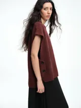 Chaleco de tejido de punto con lana y alpaca, de corte relajado y caída recta. Presenta laterales abiertos con cierre de botones y cuello redondo.