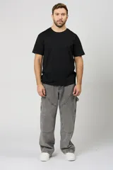 Jean baggy de hombre color gris, con diseño holgado, estilo cargo y parches en las rodillas.