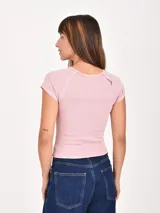 Remera de punto acanalado color rosado, de manga corta y cuello redondo.