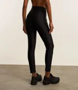 Calza deportiva negra de microfibra con detalle texturizado en la parte inferior de las piernas.