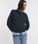 Suéter de punto azul marino, con cuello redondo y manga larga.