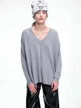 Sweater de punto color gris, con escote en V profundo, hombros caídos y diseño holgado de corte relajado.