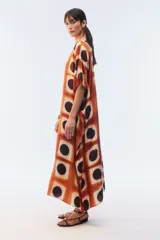Kaftan maxi amplio de color amarillo, con escote redondo, mangas cortas y ruedo irregular. Presenta un diseño estampado a cuadros con efecto teñido.