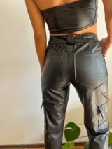 Pantalón cargo de cuero sintético negro con estampado croco, corte recto y bolsillos laterales.