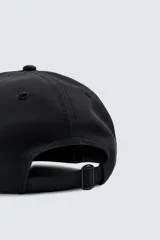 Gorra de seis paneles color negro, confeccionada en tejido técnico, con visor plano y ajuste trasero.