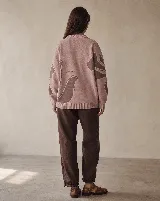 Buzo tejido de algodón y acrílico, color rosado con diseño floral en tonos marrones, de silueta amplia, cuello alto y terminaciones acanaladas.