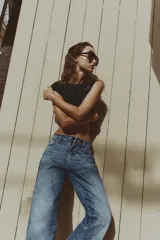 Jeans de tiro medio con diseño de cinco bolsillos, pernera recta y corte cropped. Presenta cierre frontal con cremallera y botón metálico.