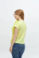 Remera color amarillo con escote en V y volantes laterales.