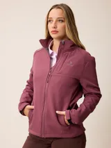 Campera softshell de color bordó, con cierre frontal completo, cuello alto y bolsillos laterales con cierre. Presenta el logo de la marca bordado en el pecho y puños ajustables.