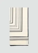 Fular cuadrado de lana con estampado geométrico de líneas negras sobre fondo color crema.