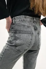 Pantalón jean gris de tiro medio alto, corte wide leg con tajo frontal.