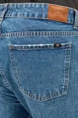 Jean Billabong de corte straight, color azul clásico, con diseño de cinco bolsillos y cierre frontal con botón y cremallera.