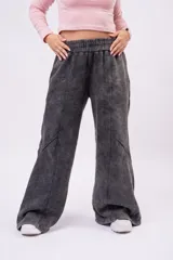 Pantalón jogger wide-leg de rústico de algodón con efecto de lavado acid wash en tono gris carbón, cintura elastizada y recortes frontales con costuras visibles.