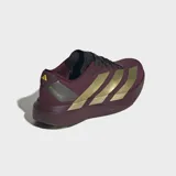 Championes de running Adidas Adizero EVO SL, color bordó con las icónicas tres tiras en dorado metalizado. Presentan una mediasuela robusta con tecnología LightstrikePro para mayor amortiguación y retorno de energía, y suela de caucho para mayor tracción.