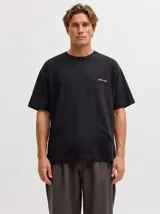 Remera negra de corte holgado, con cuello redondo, manga corta y pequeño estampado de texto en el pecho.