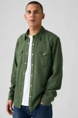Camisa de hombre verde militar, estilo western, con cuello clásico, cierre de botones a presión blancos, dos bolsillos con solapa en el pecho y costuras decorativas en los hombros.