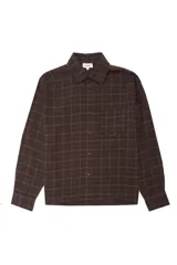 Camisa de corte boxy confeccionada en franela a cuadros, con cuello clásico, cierre frontal de botones, bolsillo en el pecho y puños abotonados.