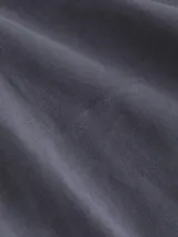 Pantalón chino de sarga elástica, corte slim y talle medio, color gris oscuro. Incluye un cinturón negro con hebilla metálica en forma de D.