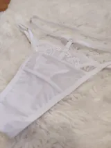 Tanga de microtul y encaje color blanco, con diseño de tiras regulables en la cintura y forro de algodón.