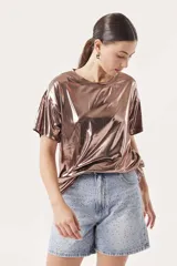 Remera de manga corta con acabado metalizado brillante en tono bronce, de corte holgado y cuello redondo.