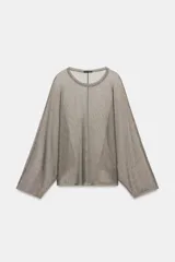 Top de cuello redondo y manga larga holgada, confeccionado en tejido con hilo metalizado de color gris.