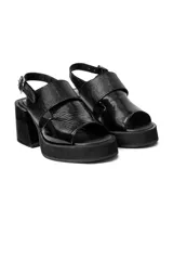 Sandalias de plataforma con taco cuadrado, confeccionadas en material sintético con acabado charol y textura tipo reptil. Cuentan con tira frontal ancha y ajuste con hebilla en el talón.