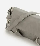 Cartera modelo baguette de tamaño pequeño, con formato estructurado, tapa delantera y detalles de hebillas decorativas. Cuenta con asa para hombro e interior forrado con compartimento.