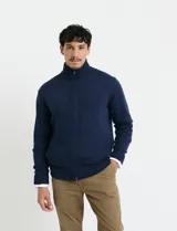 Cardigan de punto gris con cuello alto, cierre frontal de metal con doble cursor y bolsillos laterales. Presenta puños y cuello en tejido canalé.