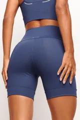 Short tipo biker de tiro alto, diseñado para running y entrenamiento. Confeccionado en tejido técnico de alta performance con bolsillos laterales funcionales y bolsillo interno en la cintura. Presenta detalles reflectivos y costuras estratégicas para mayor libertad de movimiento.