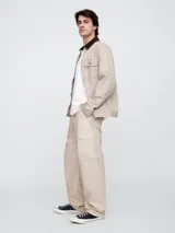 Pantalón cargo de corte holgado, confeccionado en popelina color beige, con cintura elástica ajustable mediante cordón y bolsillos laterales tipo cargo.