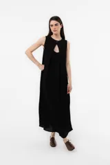 Vestido midi sin mangas de color marrón, confeccionado con textura arrugada, escote redondo, silueta relajada y caída liviana, con un lazo fino ajustable en la cintura.