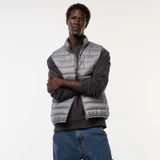 Chaleco acolchado de diseño liso en color gris, con cierre frontal de cremallera y cuello alto.