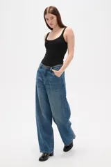 Pantalón jean de tiro medio y corte barrel con diseño amplio en las piernas, color azul.
