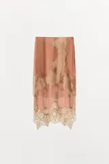 Falda midi de tiro medio confeccionada en viscosa, con diseño asimétrico y aplicación de encaje a contraste en el bajo y lateral. Cuenta con cierre lateral mediante cremallera oculta.