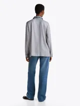 Camisa celeste con estampado de lunares blancos, de corte regular, cuello francés, cartera oculta y puños con un botón.