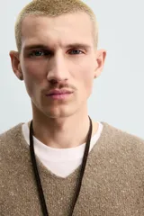 Chaleco regular fit de punto tejido en hilatura con mezcla de lana, color marrón con efecto melange. Cuenta con cuello en V y manga sisa, con acabados acanalados.