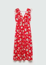 Vestido largo de tejido fluido con escote en pico cruzado y diseño evasé. Presenta tirantes anchos con detalle de lazos ajustables en los hombros y estampado floral en tonos rojos y crema.