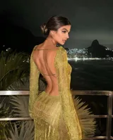 Vestido largo de tejido de punto calado color dorado, con espalda descubierta y mangas largas.