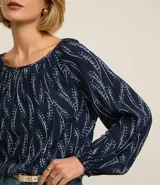 Blusa azul marino con estampa de ramos en color blanco, escote canoa, mangas largas con elástico en los puños y corte holgado.