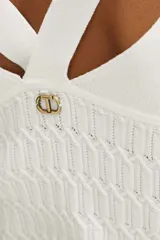 Sweater de punto color blanco, entallado, con cuello en V y escote cruzado en la espalda.