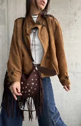 Campera tipo bomber de gamuza color camel, con diseño de doble botonadura frontal, cuello camisero y mangas largas con puños abotonados.