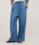 Pantalón femenino de corte wide leg, color azul, confeccionado en liocel. Presenta cintura elástica con lazo y detalle de nervura frontal.
