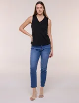 Chaleco blanco sin mangas de estilo smart-casual, con escote en V y costuras verticales de entalle. Cuenta con bolsillos o solapas simuladas a los lados de la cintura decorados con un botón metálico dorado y un largo a la cadera.