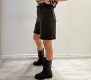 Bermuda color borgoña de gabardina elastizada, corte a la rodilla, con cinto fino con tachas y detalles de flecos en el ruedo.