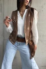 Blusa blanca de mangas largas abullonadas con puños elásticos y detalles de encaje y bordados sutiles. Presenta escote en V con tiras decorativas y diseño holgado.