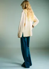 Jersey de punto de cuello alto, con diseño recto, manga larga y aberturas laterales en el ruedo.